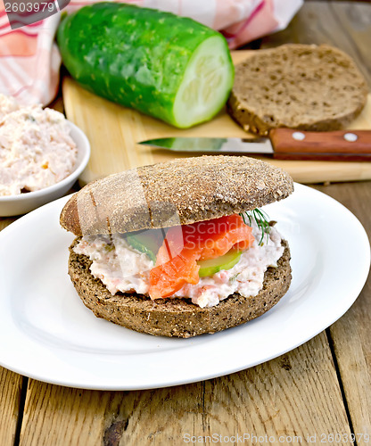 Image of Sandwich with cream and salmon with cucumber on board