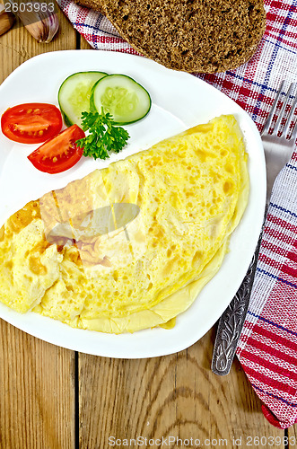 Image of Omelet with vegetables and bread on the board