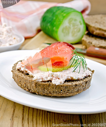 Image of Sandwich with cream and salmon with cucumber on the board