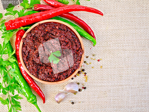 Image of Adjika with hot pepper and parsley on burlap