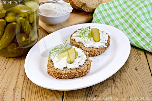 Image of Sandwich with cream and pickles on a board