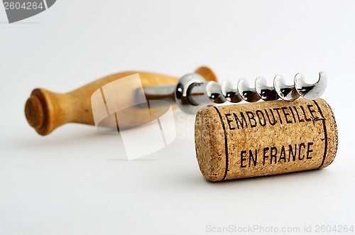 Image of vintage corkscrew and wine cork with inscription embouteille en 