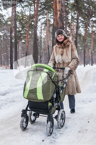Image of beautiful young mother with carriage