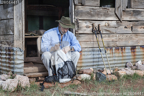 Image of hiker and old mountain cabin