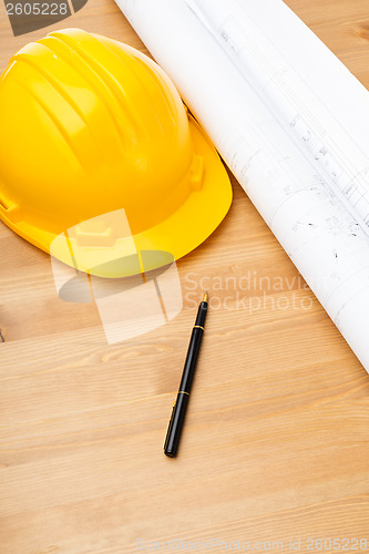 Image of Construction blue print and safety helmet