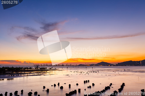 Image of Sunset over sandy beach in low tide 