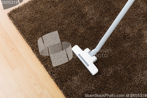 Image of Head of modern vacuum cleaner on carpet 