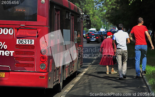 Image of bus stop, pedestrians