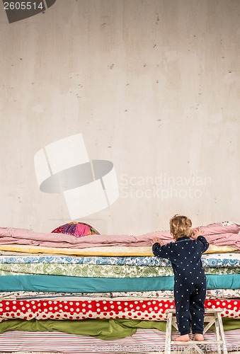 Image of Child climbs on the bed - Princess and the Pea.