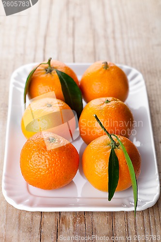 Image of tangerines with leaves in plate