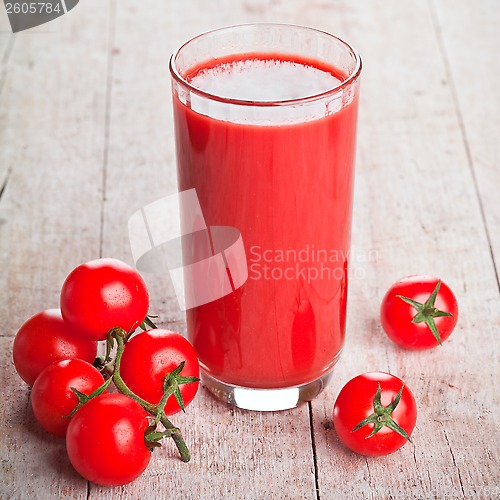 Image of tomato juice in glass and fresh tomatoes 