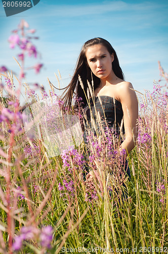 Image of Woman standing in grass and flowers