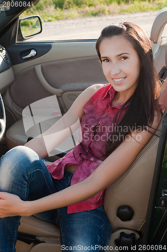 Image of Beautiful brunette woman sitting in cabrio