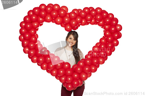 Image of Smiling woman holding red balloon heart