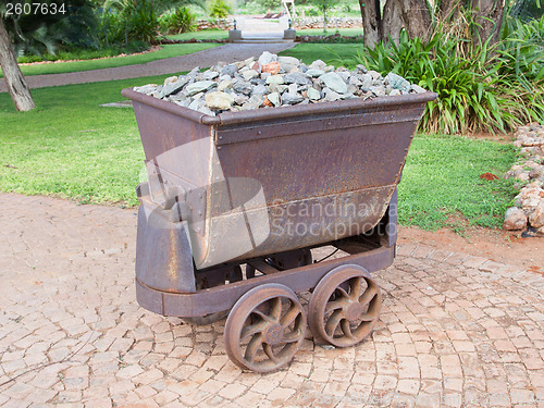 Image of Rusted old mining carriages filled with stones