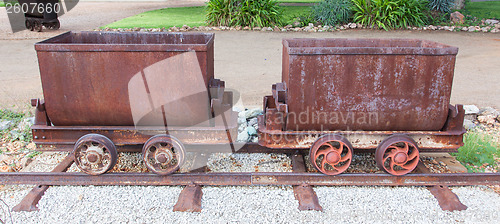 Image of Rusted old mining carriages filled with stones