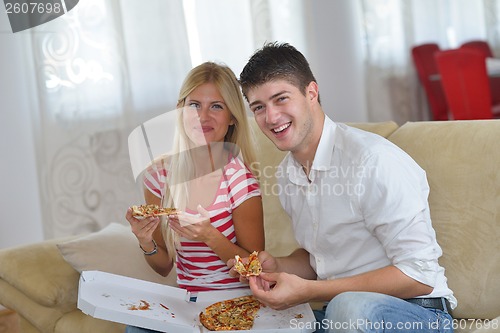 Image of couple at home eating  pizza