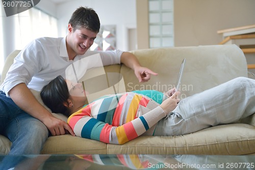 Image of pregnant couple at home using tablet computer