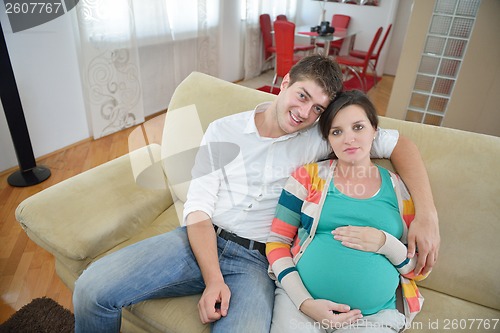 Image of pregnant couple at home using tablet computer