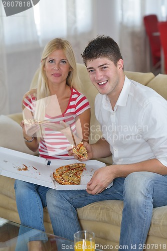Image of couple at home eating  pizza