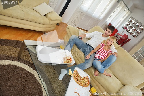 Image of couple at home eating  pizza