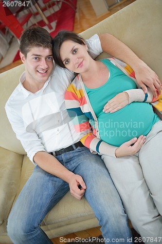 Image of pregnant couple at home using tablet computer