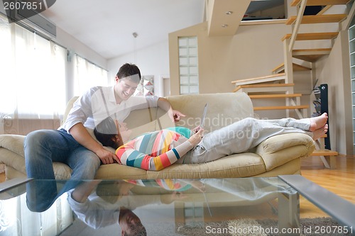 Image of pregnant couple at home using tablet computer