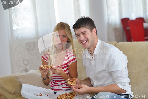 Image of couple at home eating  pizza