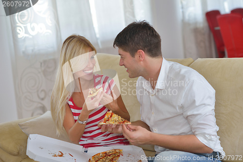 Image of couple at home eating  pizza