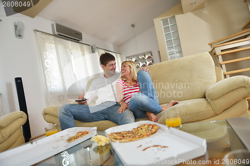 Image of couple at home eating  pizza