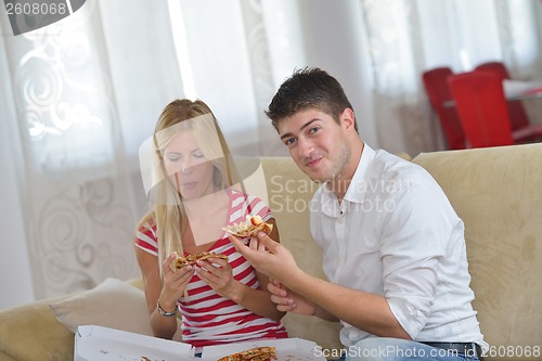 Image of couple at home eating  pizza