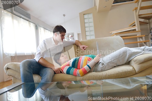 Image of pregnant couple at home using tablet computer