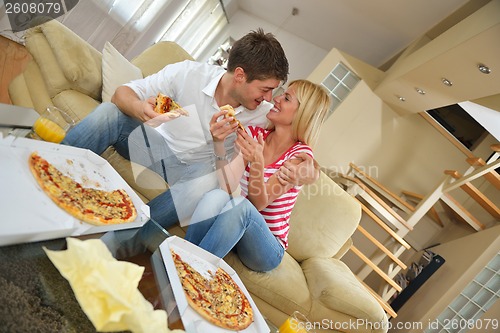 Image of couple at home eating  pizza