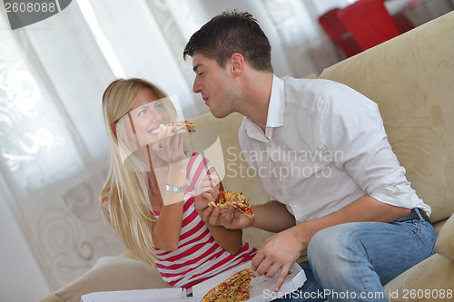 Image of couple at home eating  pizza