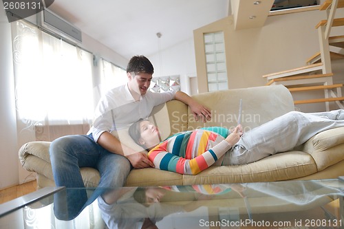 Image of pregnant couple at home using tablet computer