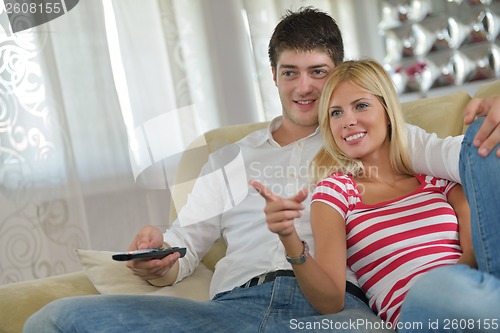 Image of Relaxed young  couple watching tv at home