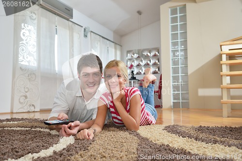 Image of Relaxed young  couple watching tv at home