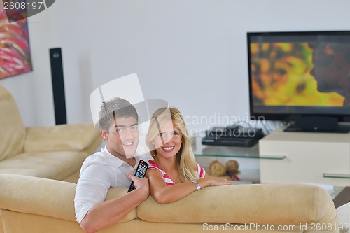 Image of Relaxed young  couple watching tv at home