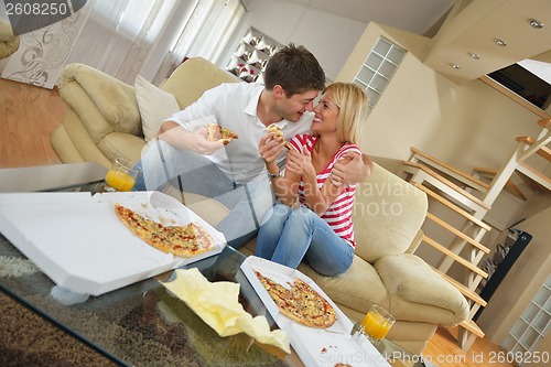 Image of couple at home eating  pizza
