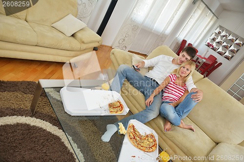 Image of couple at home eating  pizza