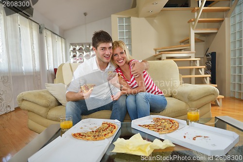 Image of couple at home eating  pizza