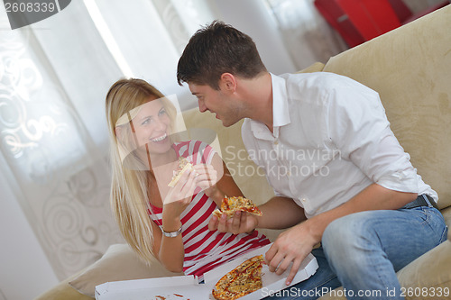 Image of couple at home eating  pizza