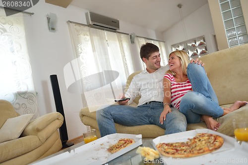 Image of couple at home eating  pizza