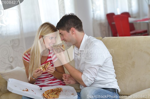 Image of couple at home eating  pizza