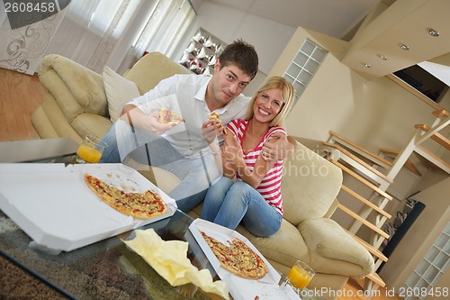 Image of couple at home eating  pizza