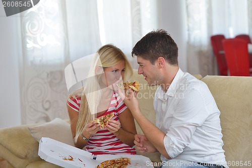 Image of couple at home eating  pizza
