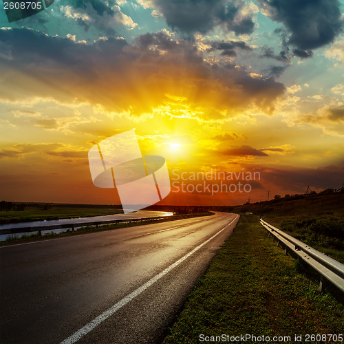 Image of dramatic sunset over asphalt road