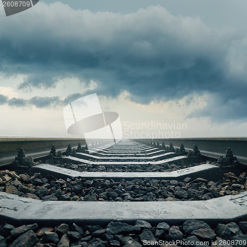 Image of railroad closeup goes to horizon in dramatic sky