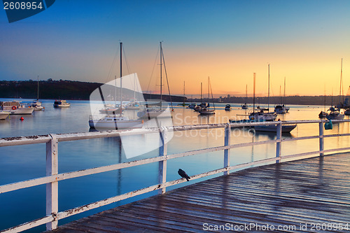 Image of Boats moored bobbing in the waters at sunrise