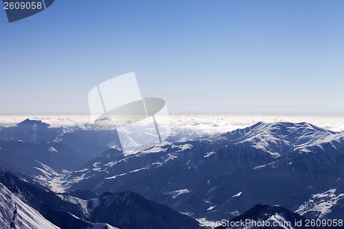 Image of View from off-piste slope on snowy mountains in haze